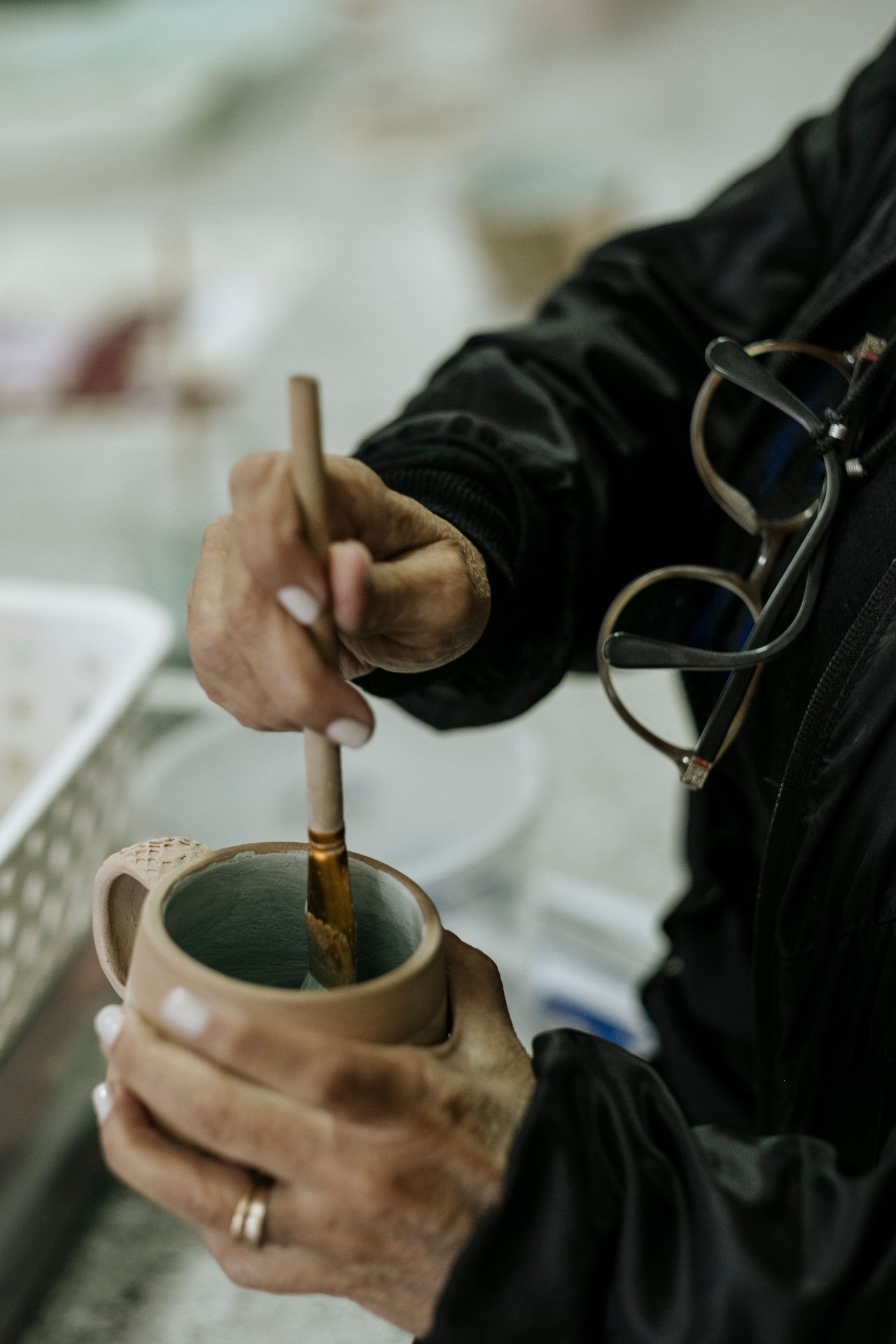 Mão pintando uma caneca de cerâmica